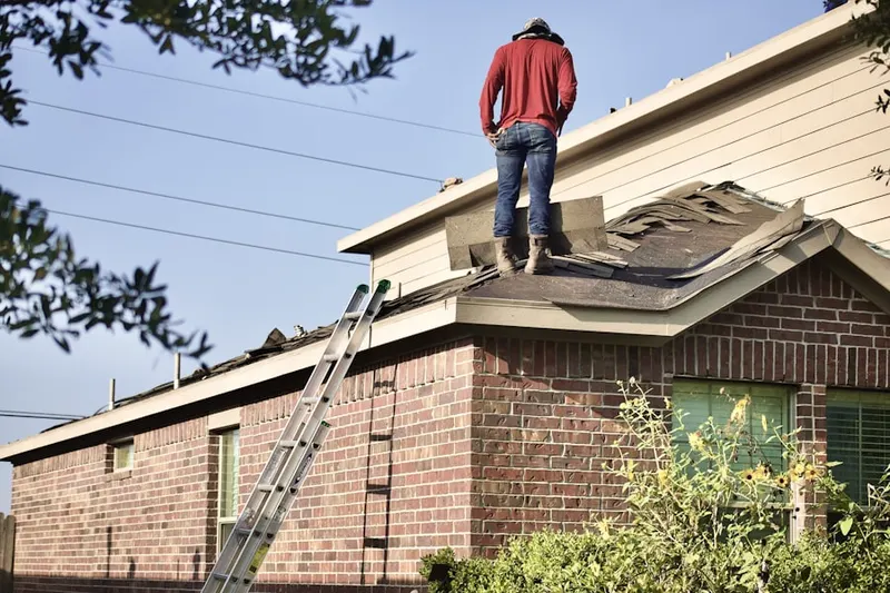 Professional roofer working on a residential roof in Independence Village